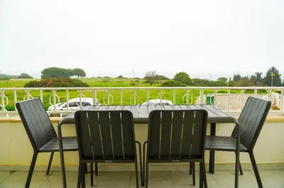 a dining room table with four chairs and a balcony at Apartment Berardo - Perfect for families in Albufeira