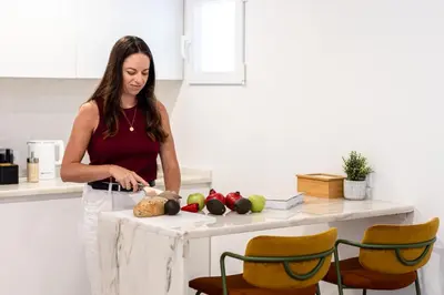 a woman standing in a kitchen preparing food at Outsite Vilamoura in Quarteira