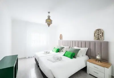 a bedroom with a large white bed with green accents at Apartment Nidio - Great Location in Albufeira