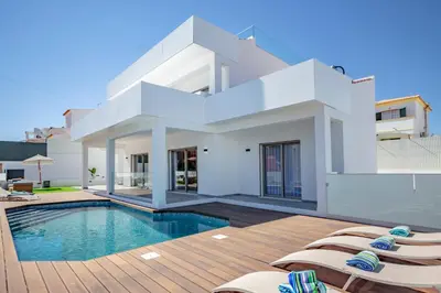 a villa with a swimming pool and lounge chairs at Crystal bay in Albufeira