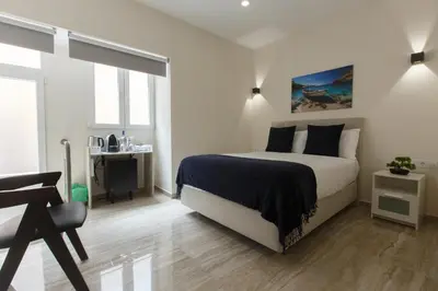 a bedroom with a bed and a desk in it at Solar Mendonca in Faro