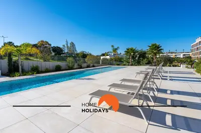 a swimming pool with a ladder next to a resort at #264 Green Apartments C04 by Home Holidays in Albufeira