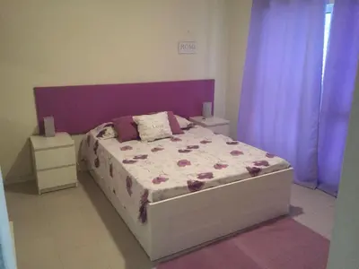 a bedroom with a bed with a purple headboard at Vivenda Fairways in Quarteira