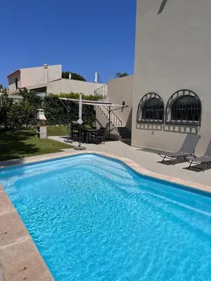 a swimming pool in front of a house at Vivenda Fairways in Quarteira