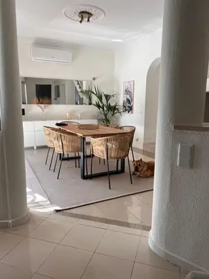 a living room with a table and chairs and a dog at Vivenda Fairways in Quarteira