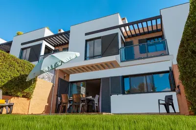 a large white house with a table and chairs at Townhouse Ocean Joy by Algarve Vacation in Albufeira