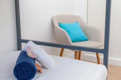 a chair and a pillow with a stuffed animal on a bed at Townhouse Ocean Joy by Algarve Vacation in Albufeira