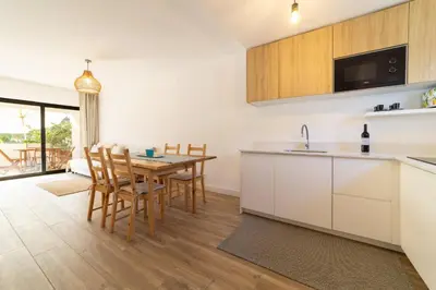 a kitchen and dining room with a table and chairs at Falésia Sunset Villa by HelloVacations in Albufeira