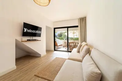 a living room with a couch and a tv at Falésia Sunset Villa by HelloVacations in Albufeira