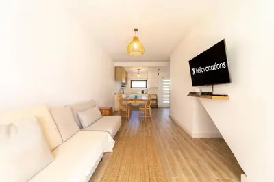 a living room with a white couch and a tv at Falésia Sunset Villa by HelloVacations in Albufeira