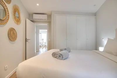 a bedroom with a white bed with towels on it at Ocean Apt 200meters Beach AC Wi-Fi Balcony in Albufeira