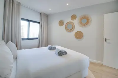 a bedroom with a white bed with towels on it at Ocean Apt 200meters Beach AC Wi-Fi Balcony in Albufeira
