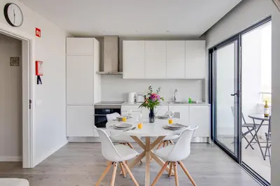 a kitchen and dining room with a table and chairs at Ocean Apt 200meters Beach AC Wi-Fi Balcony in Albufeira