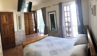 a bedroom with a bed and a tv and windows at Old Village Vilamoura Beautiful 3 Bed townhouse in Vilamoura
