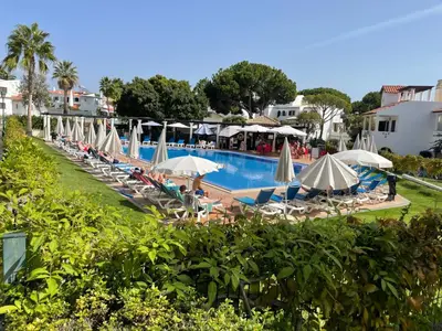 a swimming pool with lounge chairs and umbrellas at Old Village Vilamoura Beautiful 3 Bed townhouse in Vilamoura
