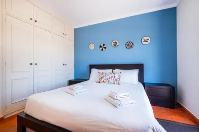 a blue bedroom with a bed with towels on it at Villa Laranja in Guia