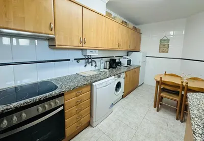 a kitchen with wooden cabinets and a washer and dryer at Appartement Talia in Albufeira