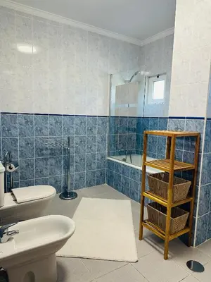 a blue tiled bathroom with a toilet and a sink at Appartement Talia in Albufeira