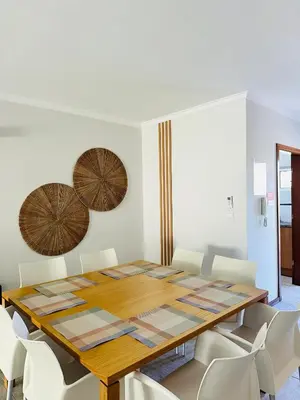 a dining room with a wooden table and white chairs at Appartement Talia in Albufeira