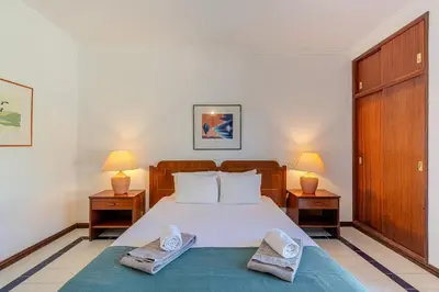 a bedroom with a large bed with two night stands at Casa Rita by Sunnyway in Olhos de Água