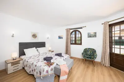 a bedroom with a bed and a chair in it at Villa Cristina 15 in Albufeira