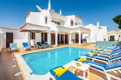 a villa with a swimming pool in front of a house at Villa Serenity in Albufeira