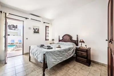 a bedroom with a bed and a dresser in it at Villa Serenity in Albufeira