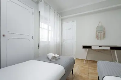 a white bedroom with a bed and a desk at ISA - Quarteira in Quarteira