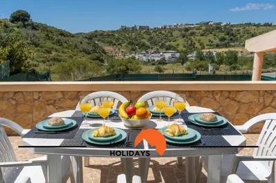 a table with fruit and juice on a balcony at #257 Villa Sun & Sea by Home Holidays in Albufeira