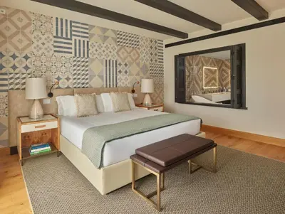 a bedroom with a large bed and a mirror at Viceroy Residences at Ombria Algarve in Loulé