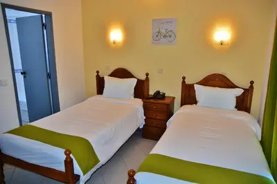 a bedroom with two beds and a night stand at Residencial A Doca in Faro