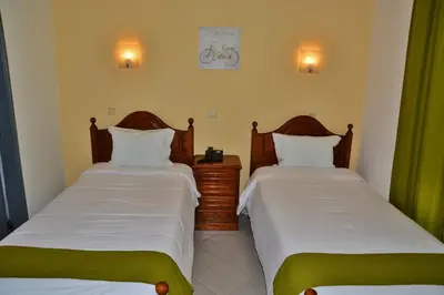 two beds in a room with green curtains at Residencial A Doca in Faro