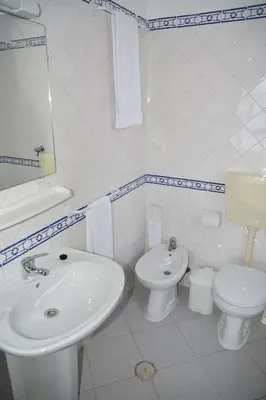 a white bathroom with a sink and a toilet at Residencial A Doca in Faro