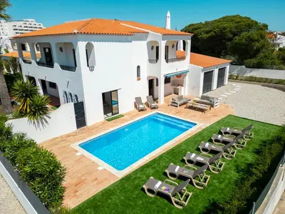 a villa with a swimming pool in front of a house at Villa Bellegarde by Algarve Vacation in Albufeira
