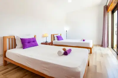 two beds in a room with purple pillows at Villa Bellegarde by Algarve Vacation in Albufeira