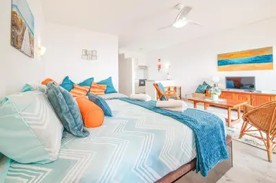 a bedroom with a large bed with colorful pillows at SeaView apartment by MOJE Holiday in Albufeira