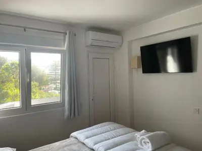 a bedroom with a bed and a tv and a window at OuraSea Apartment in Albufeira