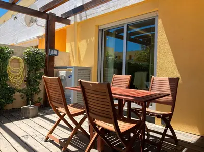 a wooden table and four chairs on a patio at Barca do Lago - Vilamoura in Vilamoura