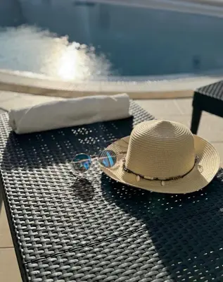 a straw hat and glasses sitting on a bench at Villa Bonita Guesthouse Albufeira Old Town in Albufeira