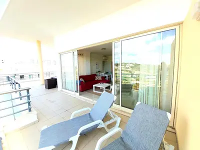 two chairs on a balcony with a view of a living room at Sea View Penthouse in Albufeira in Albufeira