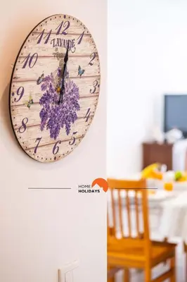 a clock hanging on a wall next to a table at #089 Largo Escola by Home Holidays in Albufeira