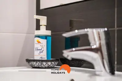 a bottle of hand sanitizer sitting next to a sink at #089 Largo Escola by Home Holidays in Albufeira
