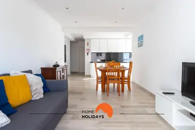 a living room and kitchen with a couch and a table at #089 Largo Escola by Home Holidays in Albufeira