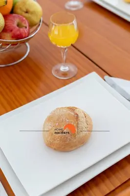 a plate with a piece of bread and a glass of orange juice at #089 Largo Escola by Home Holidays in Albufeira