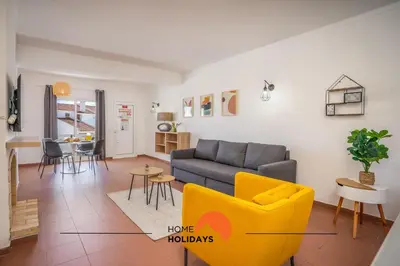 a kitchen with white cabinets and black chairs at #170 Casa do Páteo I com Alpendre by Home Holidays in Albufeira
