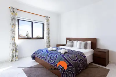 a white towel sitting on top of a bed at #191 Smile Apartment by Home Holidays in Albufeira
