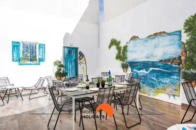 a dining room with tables and chairs and a mural at #211 Cerro Lagoa by Home Holidays in Albufeira