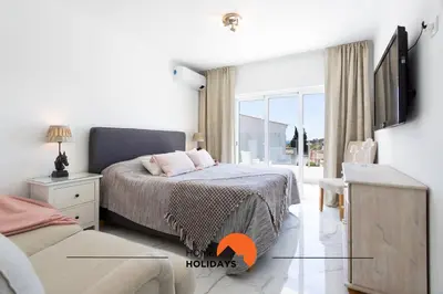a bedroom with a bed and a tv on a wall at #221 Cerro Grande by Home Holidays in Albufeira