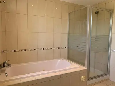 a bathroom with a tub and a glass shower at Villa Sofia in Almancil