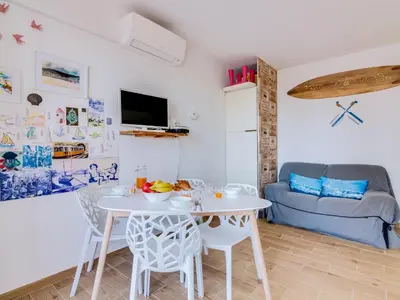 a living room with a table and chairs and a couch at Noah House, 2 bdr apartment with sea view in Quarteira